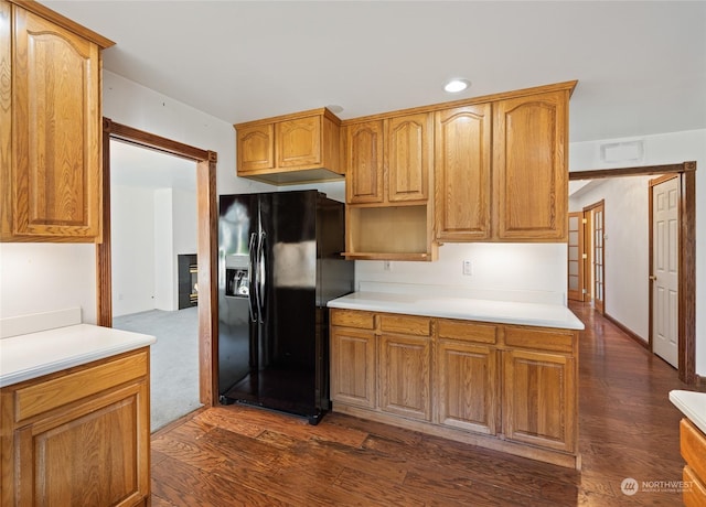 kitchen featuring black fridge and dark wood-type flooring