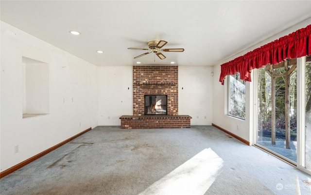 unfurnished living room featuring ceiling fan, a fireplace, and carpet floors