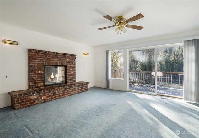 unfurnished living room with ceiling fan, carpet floors, and a brick fireplace