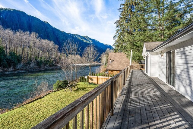 wooden deck with a lawn and a water and mountain view