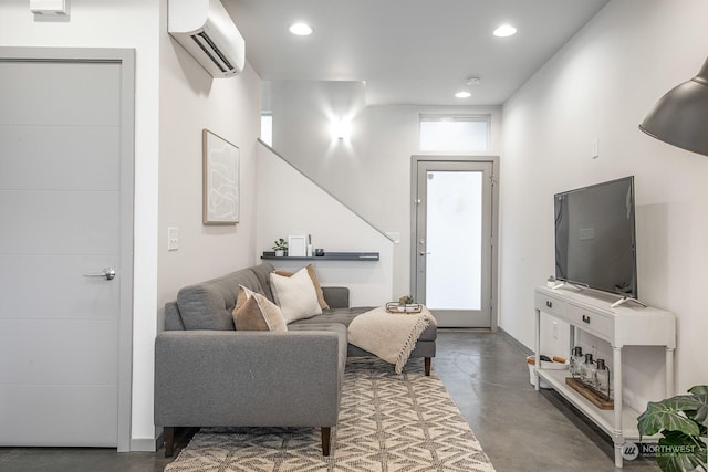 living room with concrete floors and a wall mounted AC