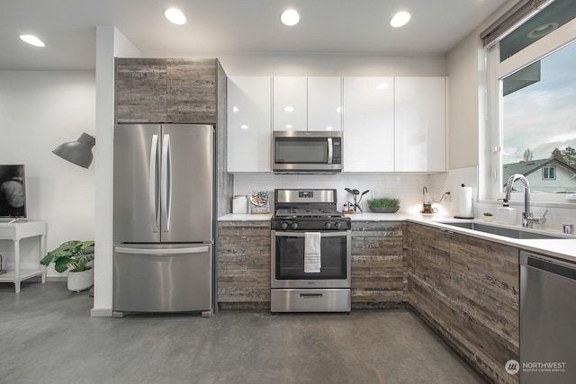 kitchen featuring backsplash, white cabinetry, sink, and stainless steel appliances