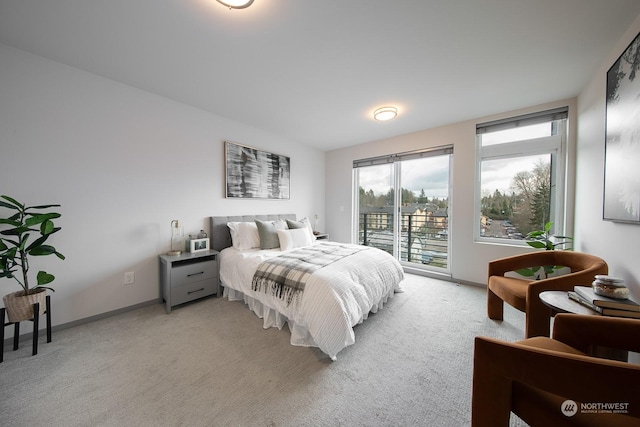 bedroom with access to exterior and light carpet