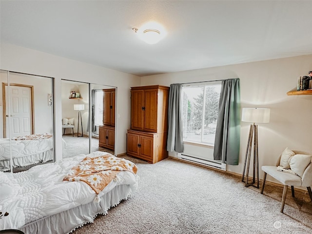 bedroom with two closets, baseboard heating, and light colored carpet