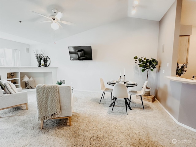 carpeted dining room featuring vaulted ceiling and ceiling fan