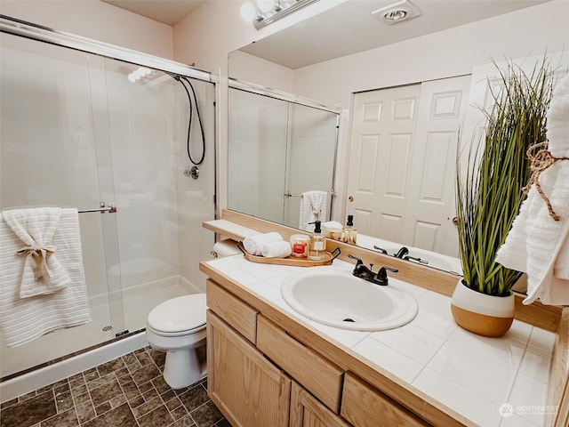 bathroom with walk in shower, vanity, and toilet