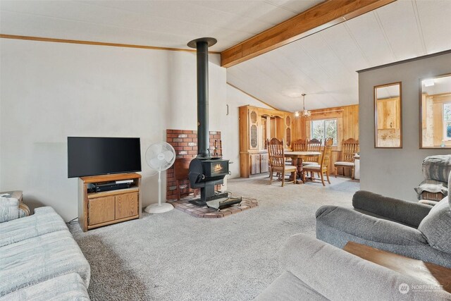 living room with lofted ceiling with beams, a wood stove, and carpet flooring