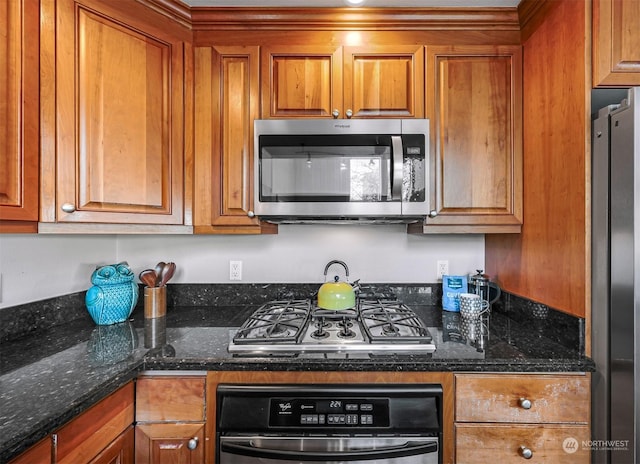 kitchen with stainless steel appliances and dark stone counters