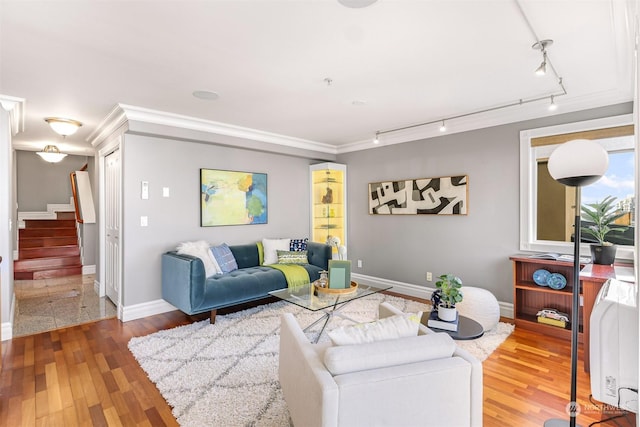 living room featuring rail lighting, ornamental molding, and hardwood / wood-style flooring