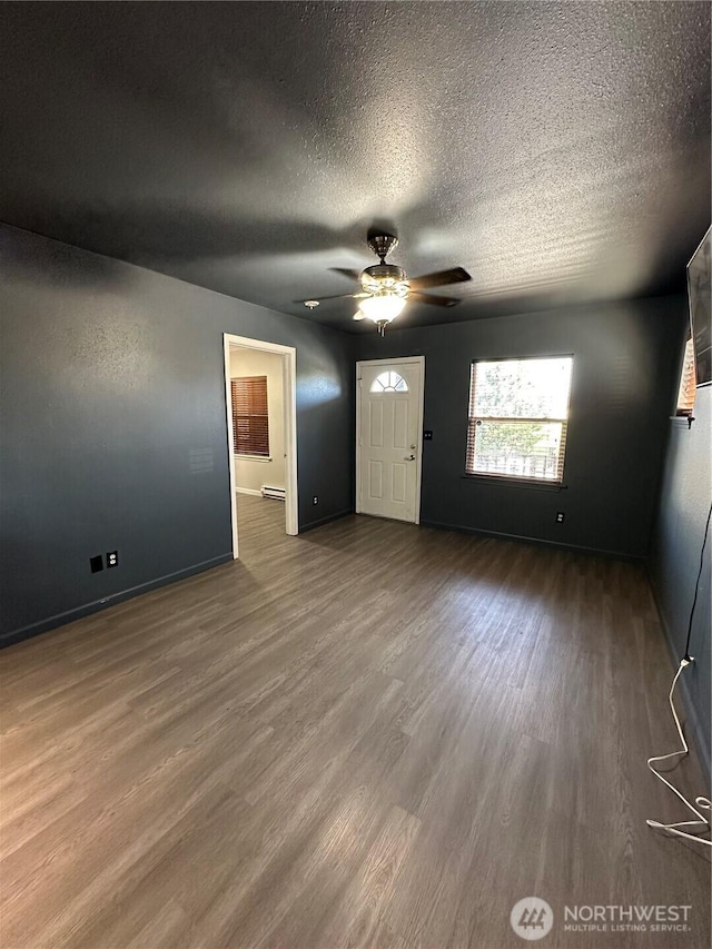 entryway featuring wood finished floors, a textured ceiling, a ceiling fan, and baseboards