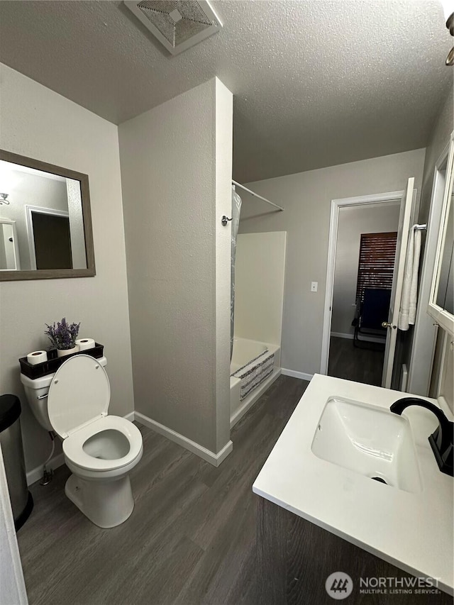 full bathroom featuring wood finished floors, visible vents, a sink, a textured ceiling, and a shower