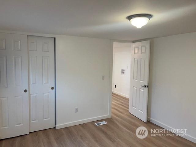 unfurnished bedroom featuring light hardwood / wood-style floors and a closet