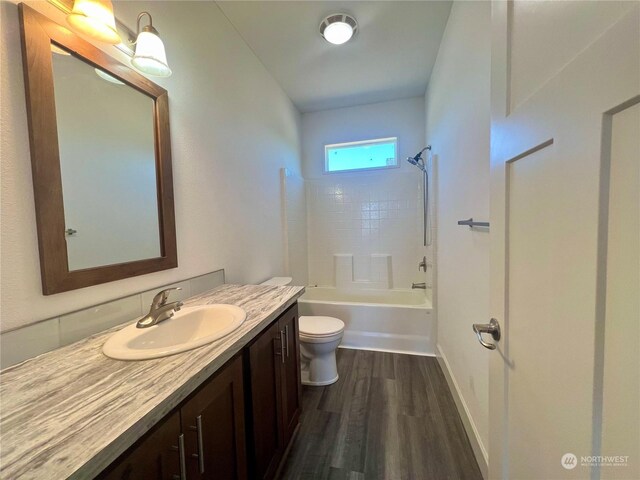 full bathroom with vanity, hardwood / wood-style floors, tub / shower combination, and toilet