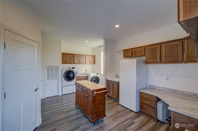 kitchen featuring butcher block countertops, a center island, separate washer and dryer, white refrigerator, and hardwood / wood-style floors