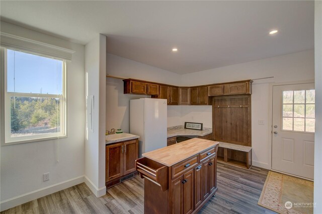 kitchen featuring sink, hardwood / wood-style flooring, a center island, and white refrigerator