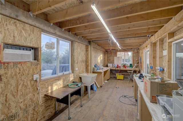 miscellaneous room with hardwood / wood-style flooring and an AC wall unit