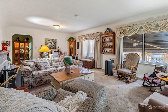 carpeted living room with radiator and a fireplace