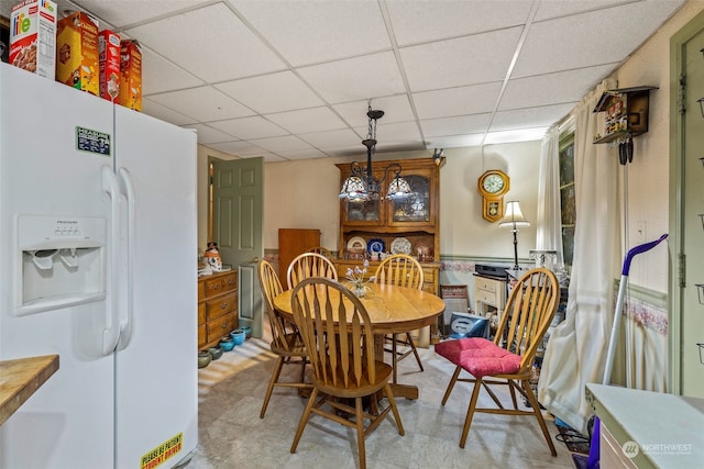 dining space with a drop ceiling