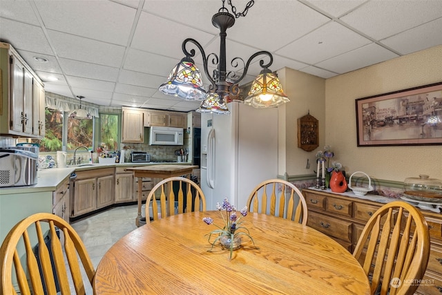 dining space featuring sink and a paneled ceiling