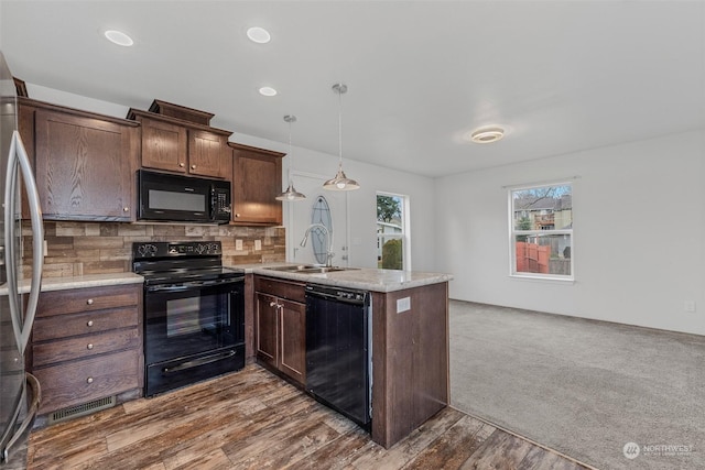 kitchen with black appliances, sink, hanging light fixtures, decorative backsplash, and kitchen peninsula