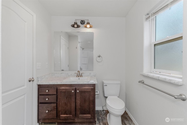 bathroom with wood-type flooring, vanity, toilet, and walk in shower