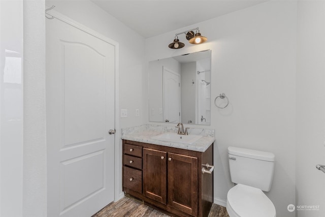 bathroom with hardwood / wood-style floors, vanity, and toilet