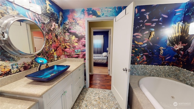 bathroom featuring vanity and a relaxing tiled tub