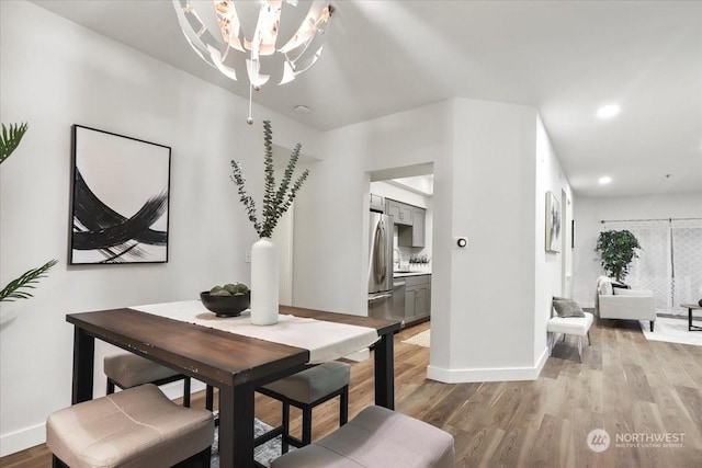 dining space featuring an inviting chandelier and light hardwood / wood-style floors