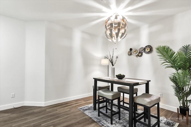 dining area featuring a notable chandelier and dark hardwood / wood-style flooring