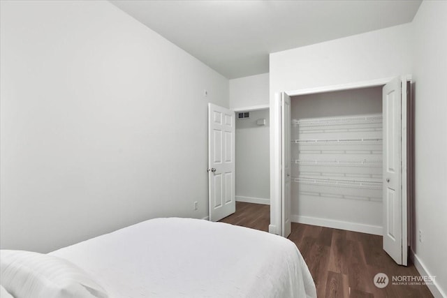 bedroom with a closet and dark hardwood / wood-style flooring