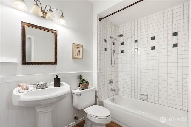 bathroom featuring tiled shower / bath and toilet