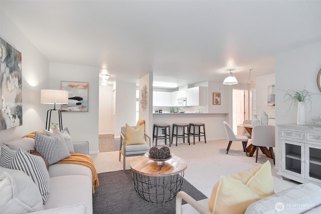 living area with light colored carpet and baseboards