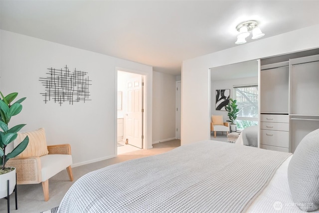 bedroom featuring light carpet, ensuite bath, and baseboards