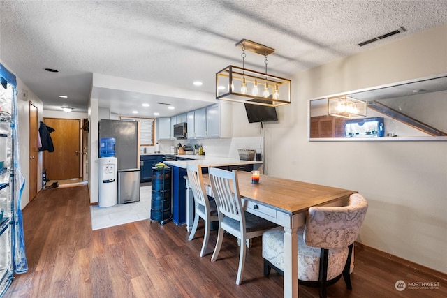 dining area with hardwood / wood-style floors and a textured ceiling