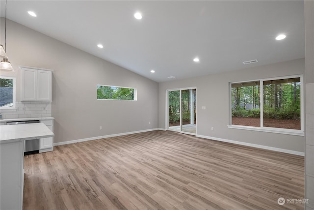 unfurnished living room with high vaulted ceiling and light hardwood / wood-style flooring