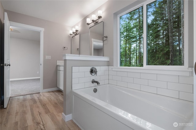 bathroom featuring a tub to relax in, vanity, and hardwood / wood-style flooring