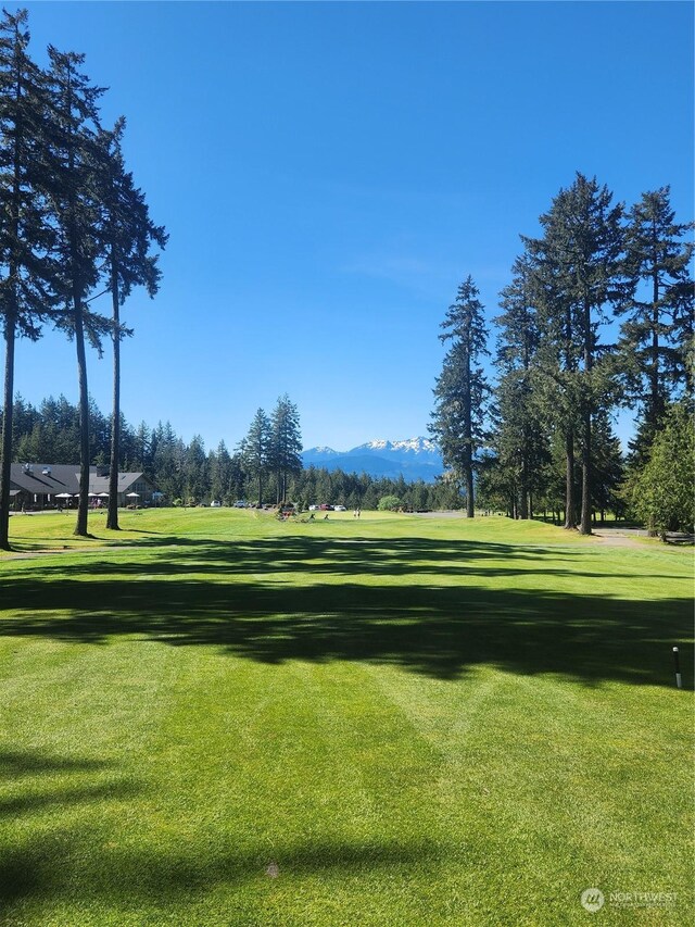 surrounding community with a mountain view and a yard