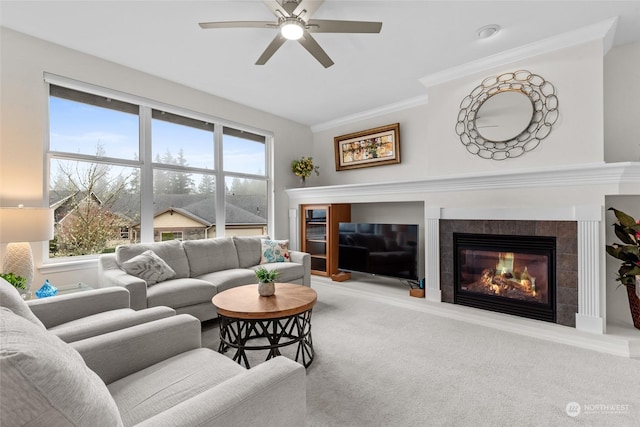 carpeted living room featuring a fireplace, ceiling fan, and ornamental molding