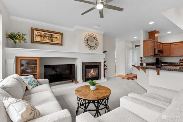 carpeted living room with a fireplace, ceiling fan, and crown molding