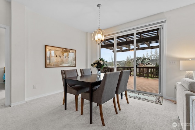 dining room featuring a notable chandelier and light carpet