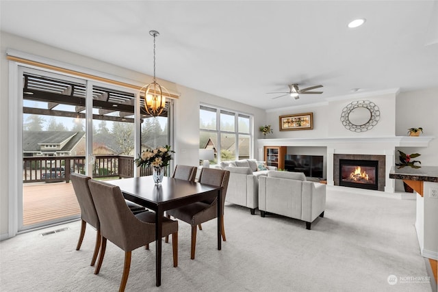 carpeted dining room featuring ceiling fan with notable chandelier