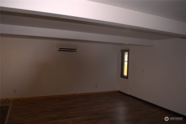 empty room featuring a wall mounted air conditioner and dark hardwood / wood-style flooring