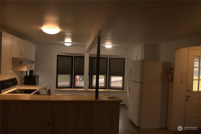 kitchen with white cabinets, white fridge, stove, and kitchen peninsula