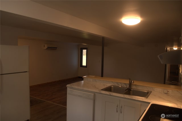 kitchen featuring white appliances, white cabinets, sink, dark hardwood / wood-style flooring, and a wall unit AC