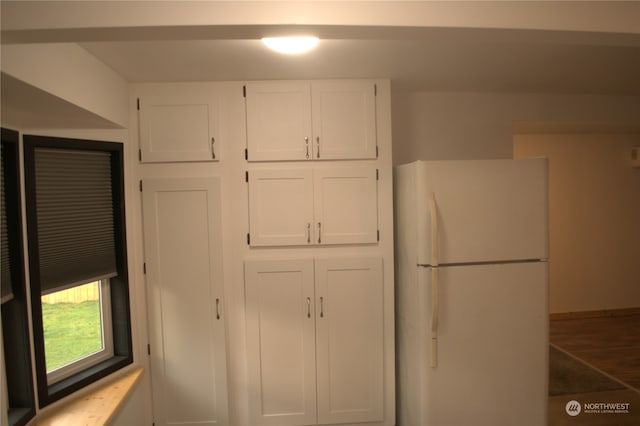 kitchen featuring white fridge and white cabinetry