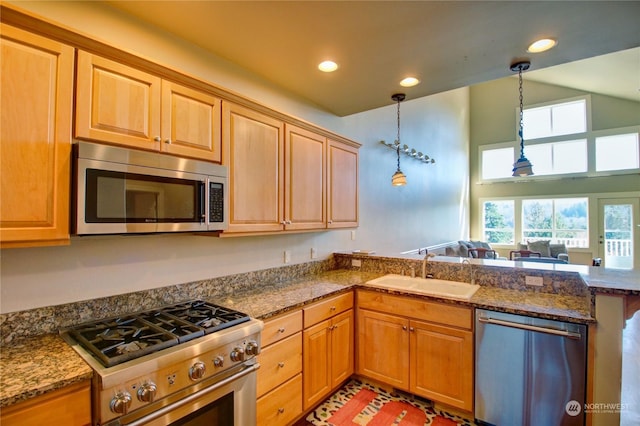 kitchen featuring pendant lighting, stainless steel appliances, dark stone counters, and sink