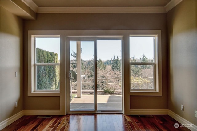 doorway with dark hardwood / wood-style floors and ornamental molding