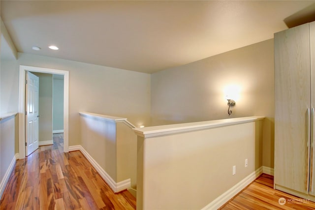 corridor with hardwood / wood-style flooring