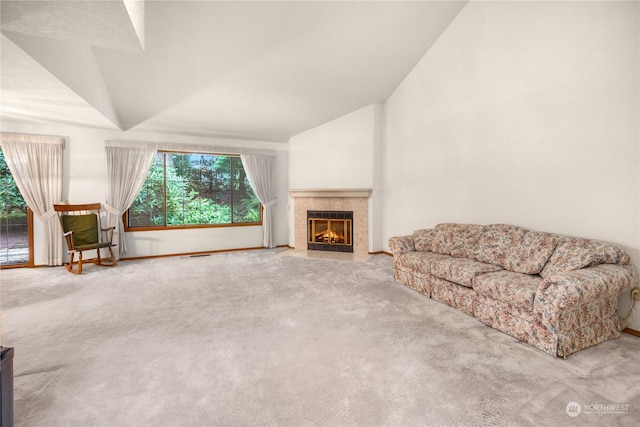 carpeted living room featuring a fireplace and vaulted ceiling