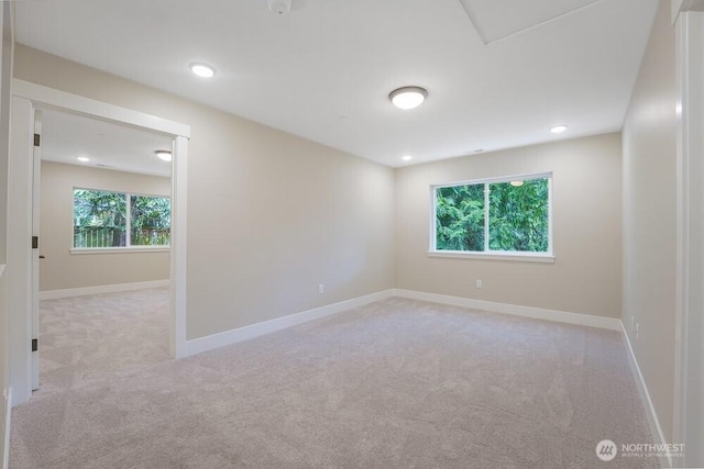 spare room featuring light carpet, baseboards, and recessed lighting